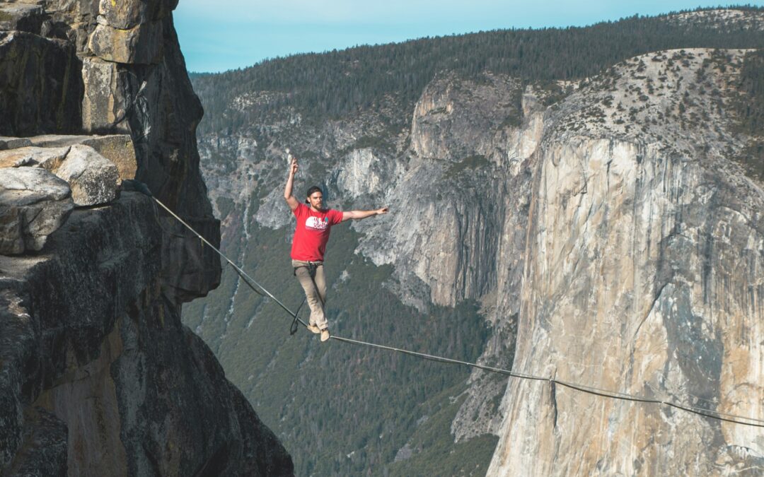 Man walking tightrope over canyon.